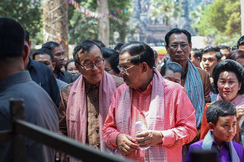 Opposition leader Sam Rainsy, left, and Prime Minister Hun Sen converse near a handicraft stall during the Angkor Sankranta festival inside the Angkor Archaeological Park on Tuesday. (Alex Willemyns/The Cambodia Daily)
