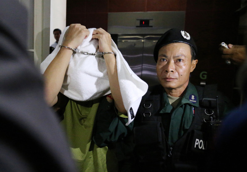 Major General Thong Sarath is led out of the Phnom Penh Municipal Court on Friday after being questioned over the November murder of Ung Meng Chue. (Satoshi Takahashi)