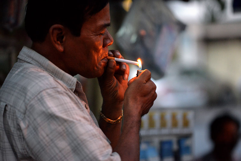 A man lights a cigarette in Phnom Penh on Wednesday evening. (Matt Walker)