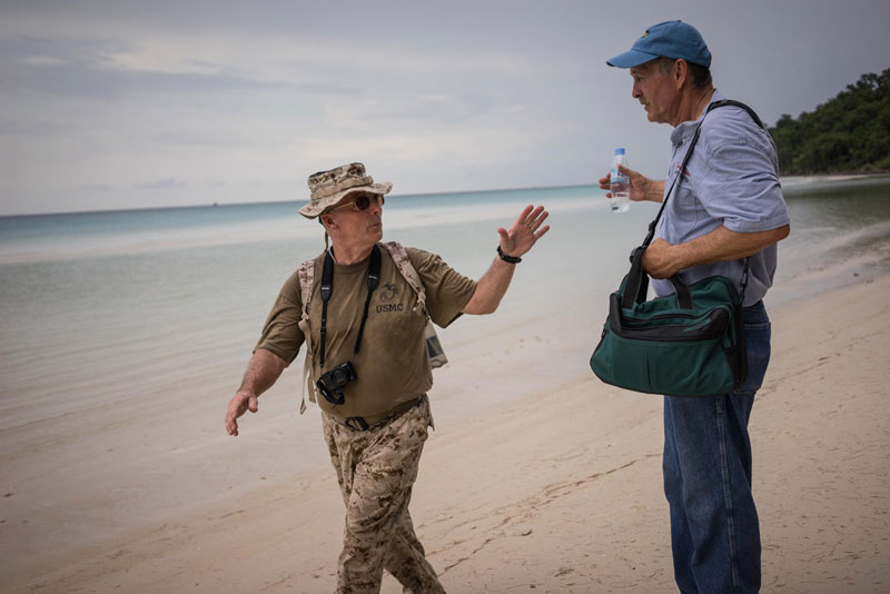 Scott Standfast, left, speaks to Cary Turner on Koh Tang’s east beach on Tuesday. (Ben Woods/The Cambodia Daily)