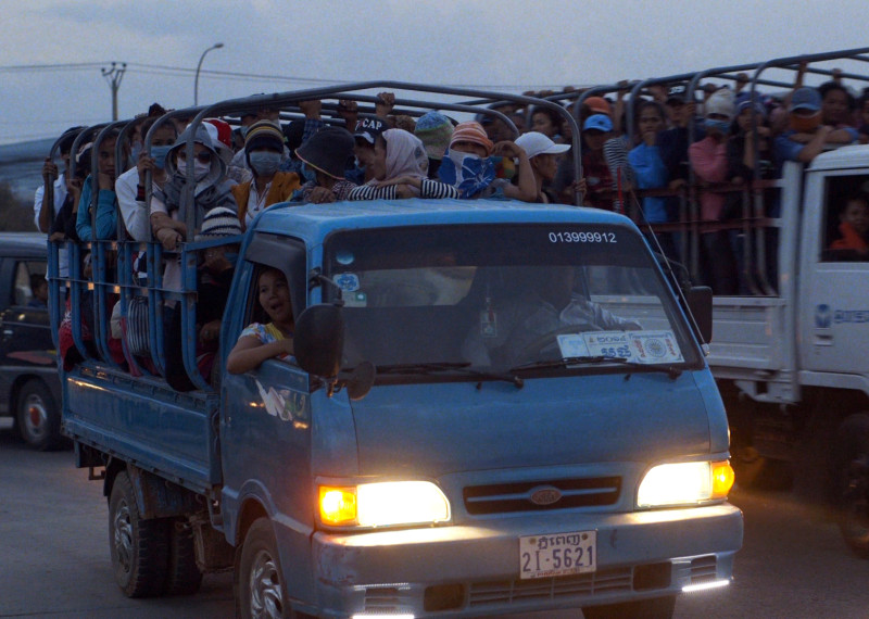 Cambodian garment workers travel to work in the back of a truck in a still image from "The True Cost."