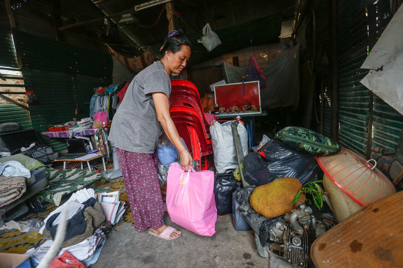 Mok Siv Hong packs away belongings at her family's home in Phnom Penh's Tuol Kok district on Monday. (Siv Channa/The Cambodia Daily) 
