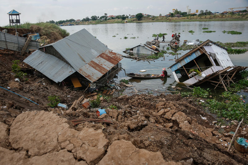 Five houses sink into the Tonle Sap River on Monday, following the collapse of about 20 meters of riverbank in Phnom Penh's Russei Keo district on Sunday.