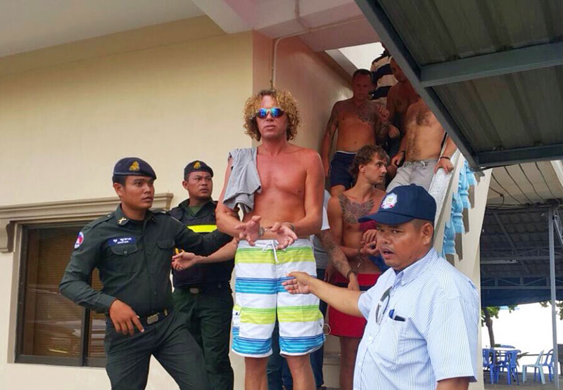 Sergei Polonsky is escorted down a flight of stairs by military police in Sihanoukville following his arrest Friday on an island off the coast, in a photograph supplied by the local news website Fresh News.