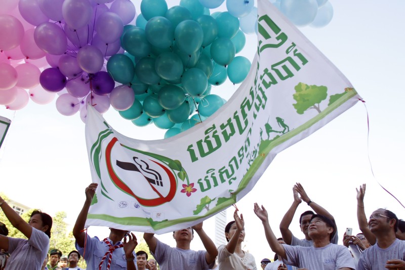 People hold up a banner which reads 'We Love an Environment Free of Smoke' at an anti-tobacco event at Wat Phnom on Friday. (Khem Sovannara)