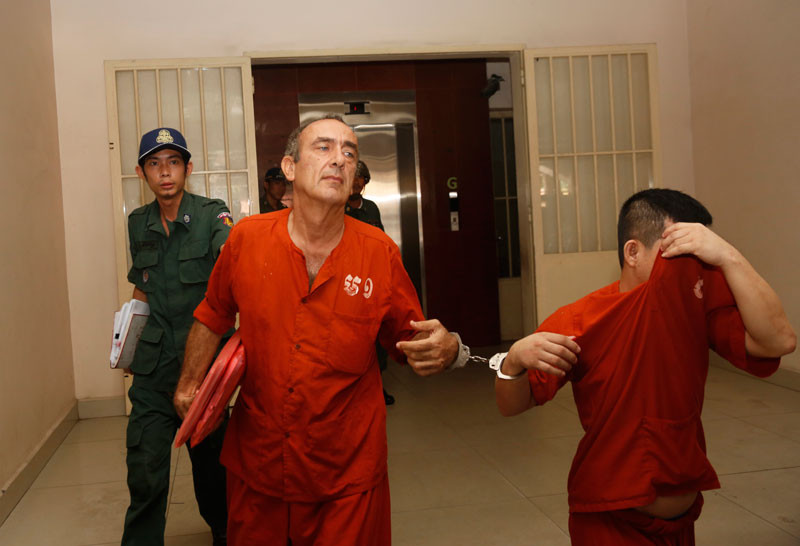 Prison guards escort accused child rapist George Moussallie out of the Phnom Penh Municipal Court on Tuesday. (Siv Channa/The Cambodia Daily)