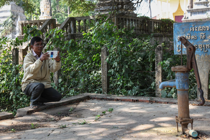 Ly Khun takes a photograph of a well in Prey Veng province during a training session for rural development officials learning to use a new app that maps wells. (Martina Tomassini/Unicef)