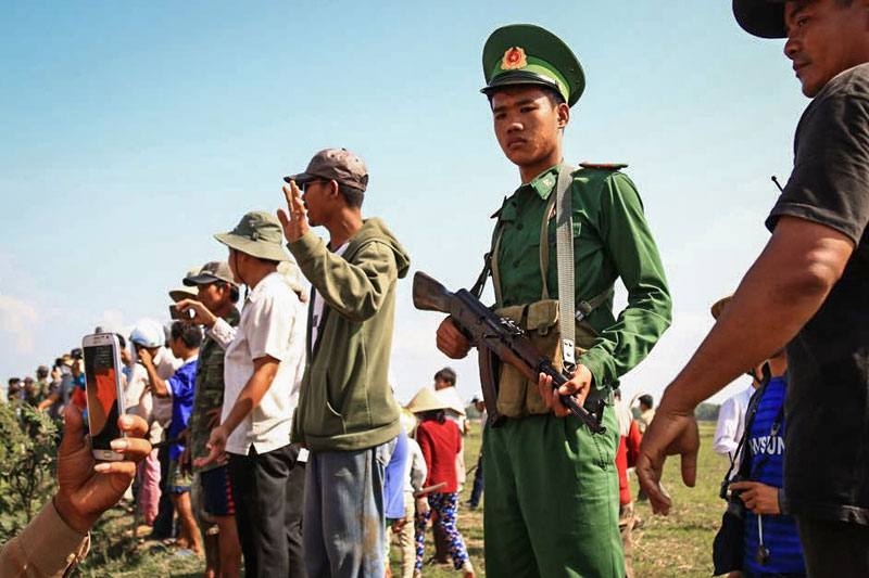 A Vietnamese soldier stands alongside Vietnamese civilians who brawled with Cambodian activists in Svay Rieng province on Sunday. (Ma Chettra)
