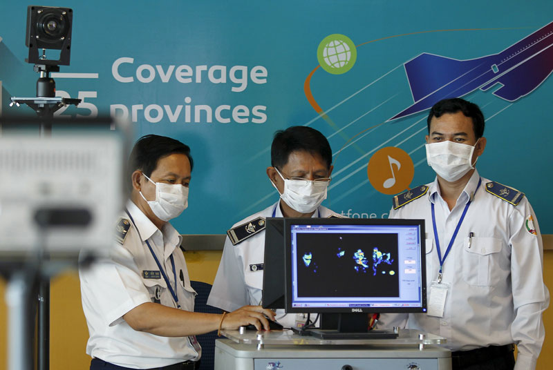 Officials from the Health Ministry's communicable disease control department operate a thermal scanner at Phnom Penh International Airport on Tuesday. (Reuters)