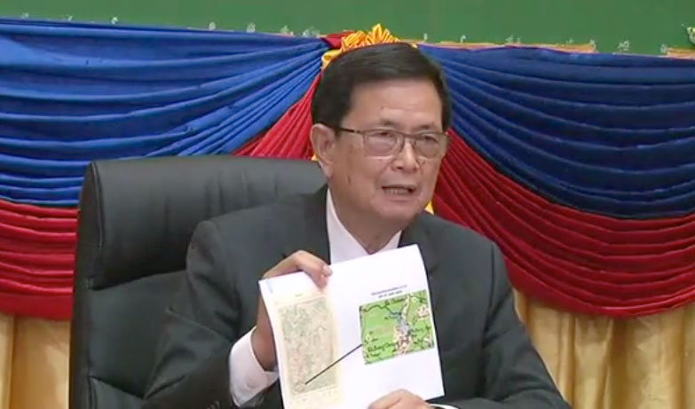 Va Kimhong, chairman of Cambodia's border committee, holds up a map during a roundtable discussion on Tuesday about disputed land along the border with Vietnam, in a still image from a video produced by the Council of Ministers.