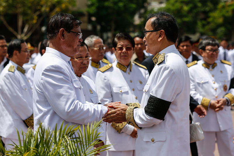From left: Interior Minister Sar Kheng and Senate President Say Chhum, who were both named vice presidents of the ruling CPP on Saturday, greet opposition leader Sam Rainsy during the cremation ceremony for late CPP President Chea Sim at Phnom Penh's Wat Botum park on Friday. (Siv Channa/The Cambodia Daily)