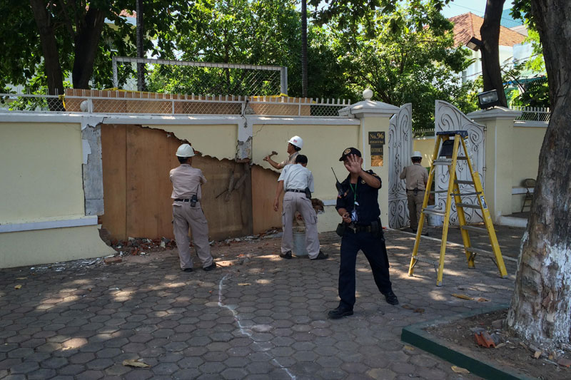 Workers repair the wall surrounding U.S. Ambassador William Todd's residence on Norodom Boulevard in Phnom Penh on Wednesday morning. (Ben Woods/The Cambodia Daily)