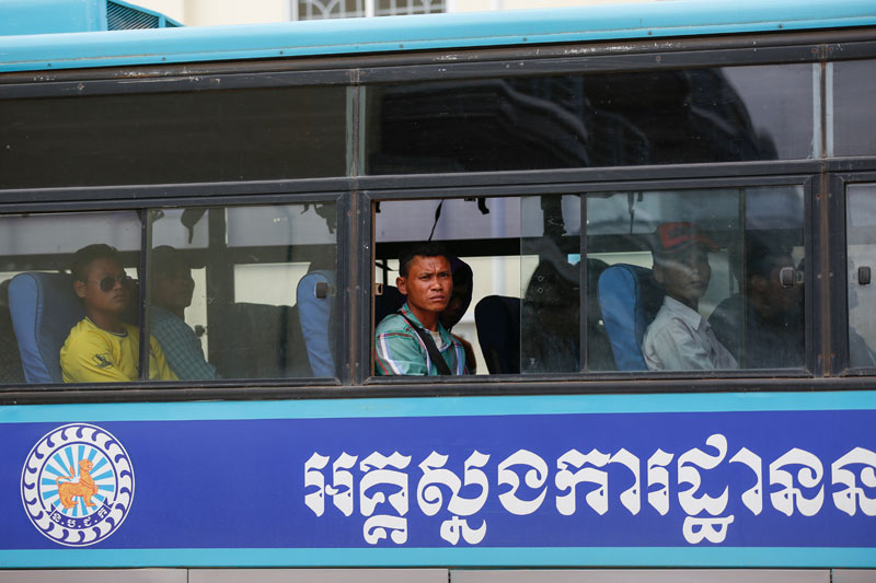 Cambodian fishermen sit inside a police bus at Phnom Penh International Airport on Thursday after arriving from Indonesia. (Siv Channa/The Cambodia Daily)