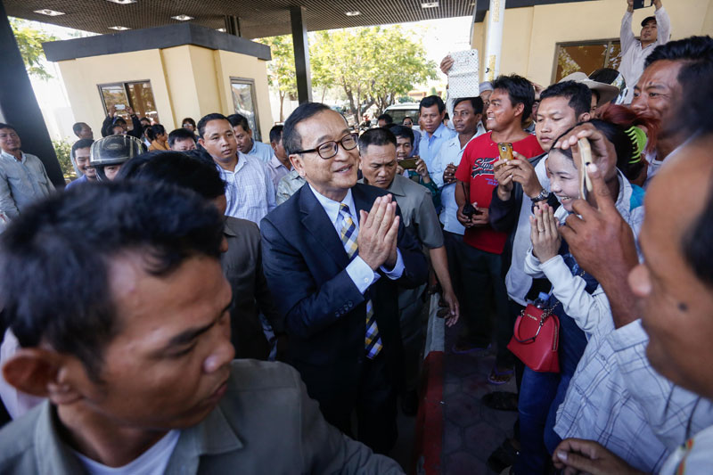 Opposition leader Sam Rainsy greets supporters at Phnom Penh International Airport on Wednesday morning after returning from a monthlong trip to Europe, Canada and the US. (Siv Channa/The Cambodia Daily)