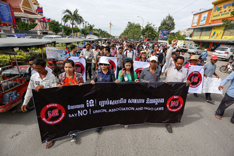 Protesters opposed to a draft law regulating the country's NGOs march away from the National Assembly, where parliament's permanent committee met Tuesday morning to discuss the legislation. (Siv Channa/The Cambodia Daily)