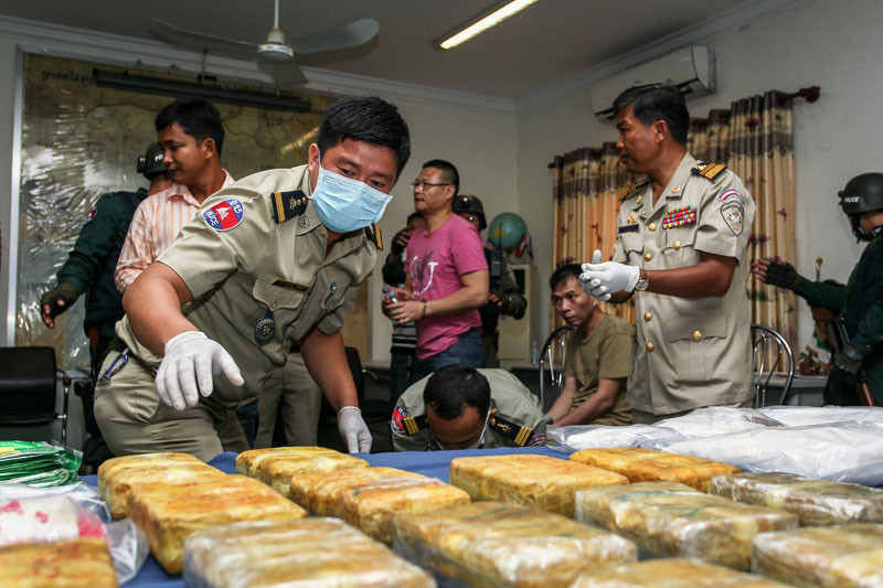 Police officers from the Interior Ministry's anti-drug department place packages of methamphetamine on a table ahead of a press conference at the National Police headquarters in Phnom Penh last year. (Masayori Ishikawa)