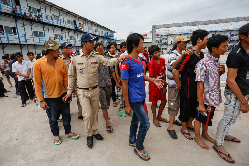 Police line up suspected illegal migrant workers Tuesday on Phnom Penh's Koh Pich island. (Siv Channa/The Cambodia Daily)