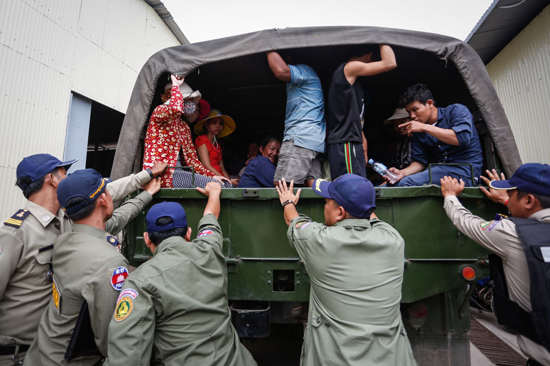 Police send off a group of suspected illegal migrant workers Tuesday on Phnom Penh's Koh Pich island. (Siv Channa/The Cambodia Daily)