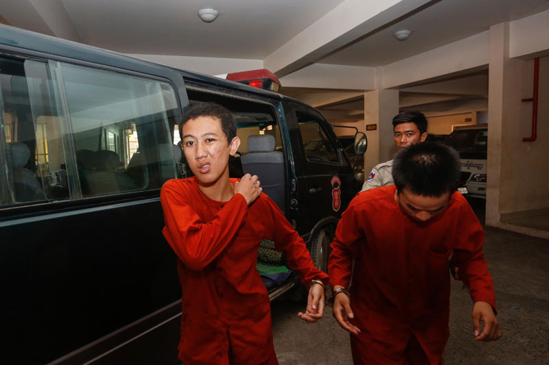Former monk Chan Sopheak is escorted Thursday from a prison van at the Phnom Penh Municipal Court, where he stood trial for murdering a senior monk at Samakki Raingsey pagoda. (Siv Channa/The Cambodia Daily)