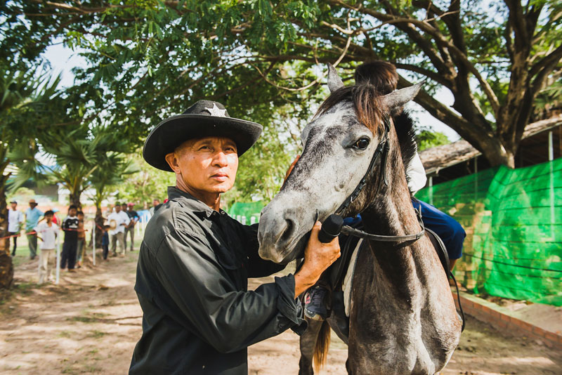 Keo Vannarin leads his horse, Spirit, from the stables to the racetrack in Phnom Penh’s Prek Pnov district last Saturday. (William Kelly)