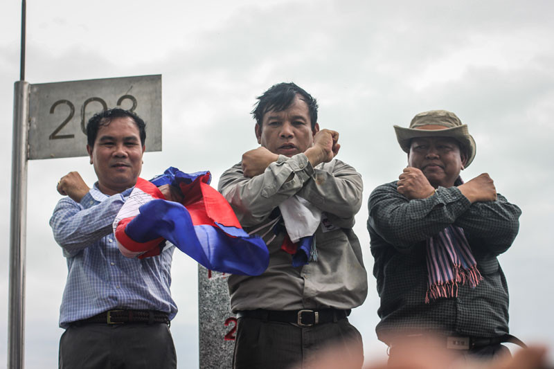 From left: CNRP lawmakers Un Sam An, Real Camerin and Cheam Channy pose while standing on border post 203 on last year. (Alex Willemyns/The Cambodia Daily)
