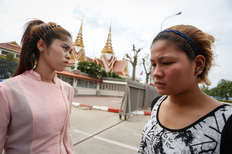 Bun Chenda, left, and Keo Nea, who were shot by Chhouk Bundith in 2012, stand outside the National Assembly on Monday. (Siv Channa/The Cambodia Daily)
