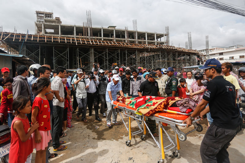 The body of Va Sok, 52, is taken away from the scene of a construction site accident in Phnom Penh's Pur Senchey district on Wednesday. (Siv Channa/The Cambodia Daily)