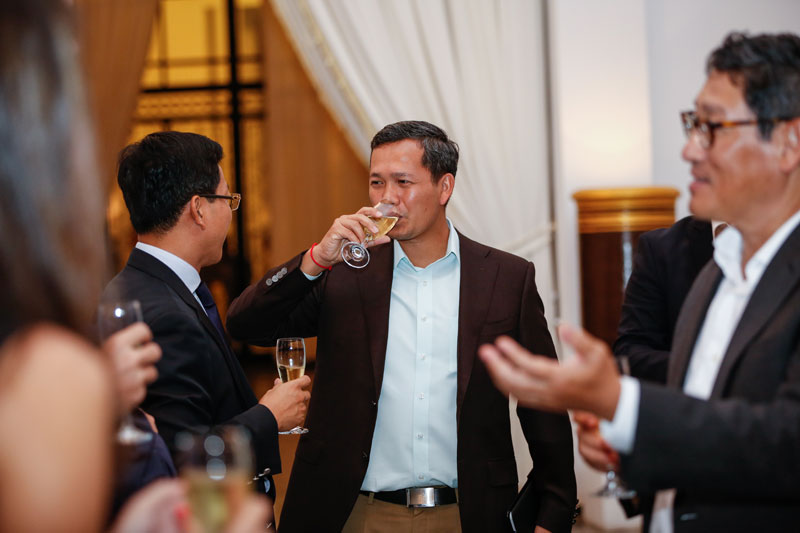 Hun Manet, the eldest son of Prime Minister Hun Sen, sips champagne during a farewell meeting between government officials and the production crew of 'Survivor Cambodia' at the Council for the Development of Cambodia in Phnom Penh on Wednesday evening. (Siv Channa/The Cambodia Daily)