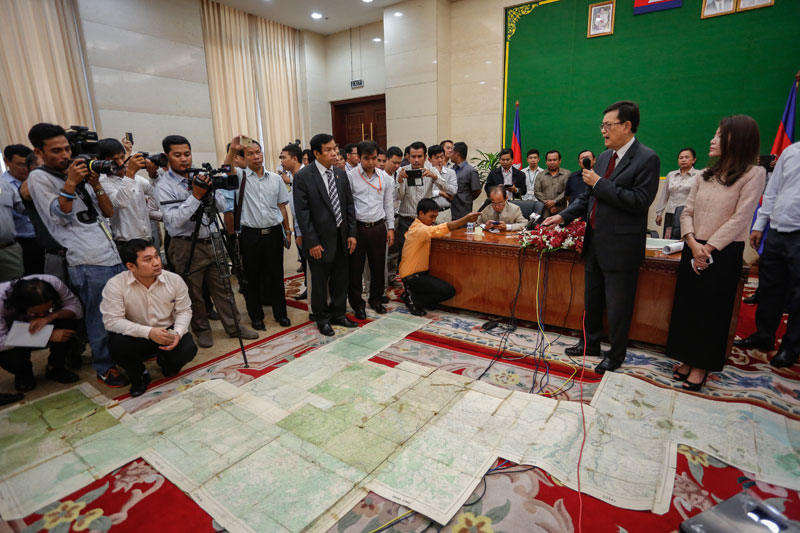 Var Kimhong, right, the chairman of the joint border committee with Vietnam, presents French-drawn maps of the Cambodia-Vietnam border to reporters and opposition lawmakers at the Council of Ministers in Phnom Penh on Thursday. (Siv Channa/The Cambodia Daily)