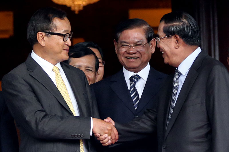 Opposition leader Sam Rainsy, left, and Prime Minister Hun Sen shake hands upon emerging from the Senate on July 22 last year. (Siv Channa/The Cambodia Daily)