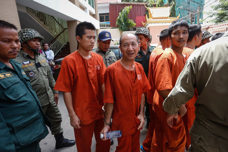 Chhay Vet, center, and other alleged members of the Khmer National Liberation Front leave the Phnom Penh Municipal Court on Tuesday after the first day of their 'plotting' trial. (Siv Channa/The Cambodia Daily)