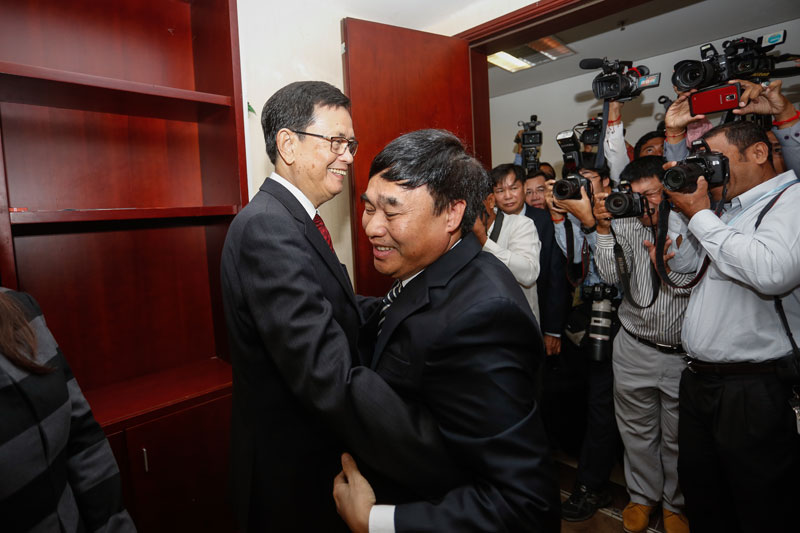 Var Kimhong, left, embraces Ho Xuan Son as he arrives for Tuesday's Joint Border Committee meeting in Phnom Penh. (Siv Channa/The Cambodia Daily)