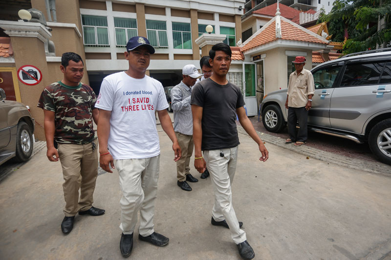 From left: Daun Penh district security guards Kim Det, Ouk Kongkea and Yul Prech leave the Phnom Penh Municipal Court on Tuesday after testifying in the trial of 11 CNRP activists charged with insurrection. (Siv Channa/The Cambodia Daily)