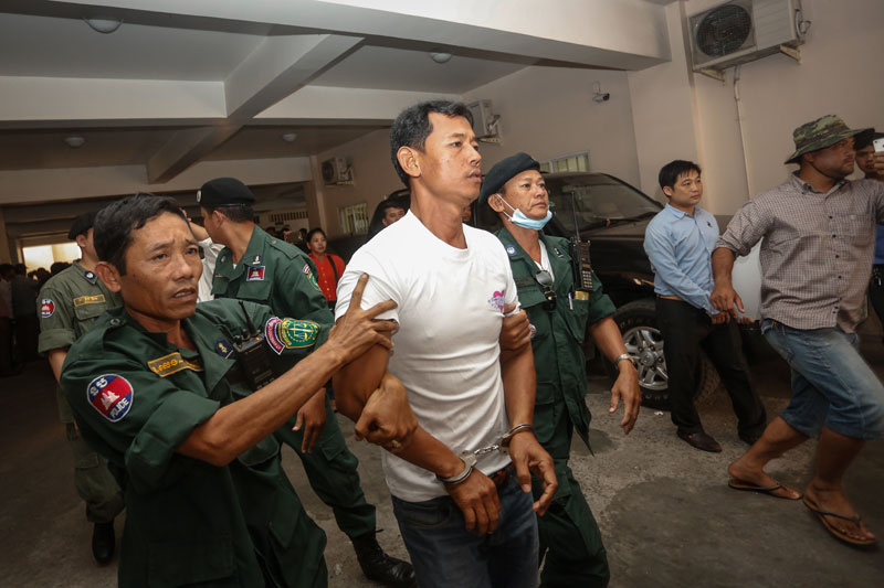 Tuk-tuk driver and opposition activist Ke Khim is escorted from the municipal court Tuesday after being sentenced to seven years in prison. (Siv Channa/The Cambodia Daily)