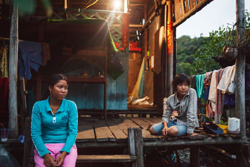 Lim Phorn, left, sits outside her home. (Jens Welding Ollgaard/The Cambodia Daily)