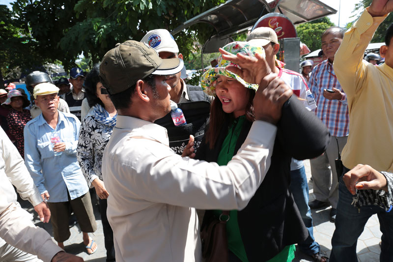A protester and a Daun Penh district security guard scuffle during a demonstration near Phnom Penh City Hall on Thursday. (Satoshi Takahashi)