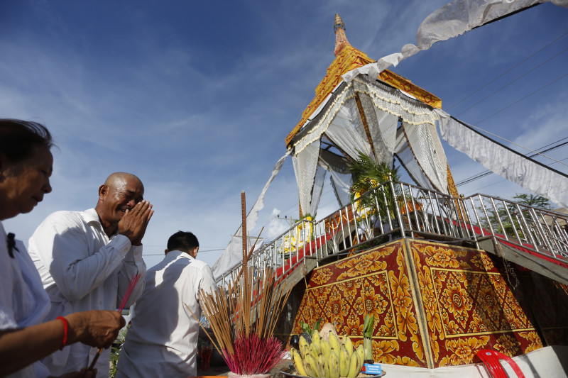 Mourners pray at a funeral pyre for two of the 16 people who died in a bus crash in Oddar Meanchey province on Thursday. (Siv Channa/The Cambodia Daily)