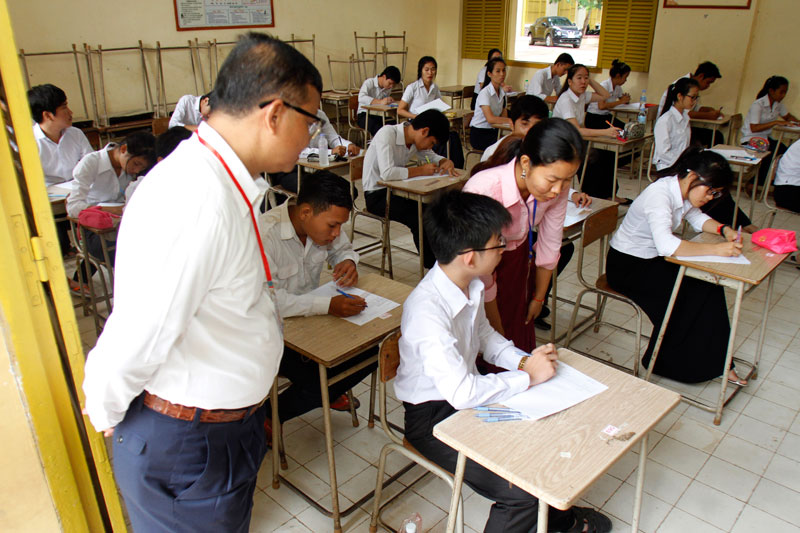 Education Minister Hang Chuon Naron watches students taking the grade 12 national exam at Preah Sisowath High School in Phnom Penh on Monday. (Khem Sovannara)
