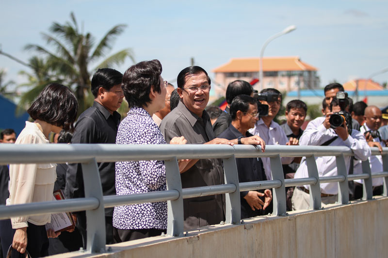Prime Minister Hun Sen speaks with Chinese Ambassador Bu Jianguo on Monday during the inauguration of the Cambodian-Chinese Friendship Bridge in Kandal province's Takhmao City. (Siv Channa/The Cambodia Daily)