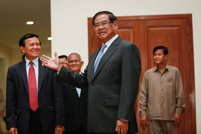 Interior Minister Sar Kheng gestures toward deputy opposition leader Kem Sokha on Monday at the National Assembly in Phnom Penh, where the two met to discuss recent political issues. (Siv Channa/The Cambodia Daily)