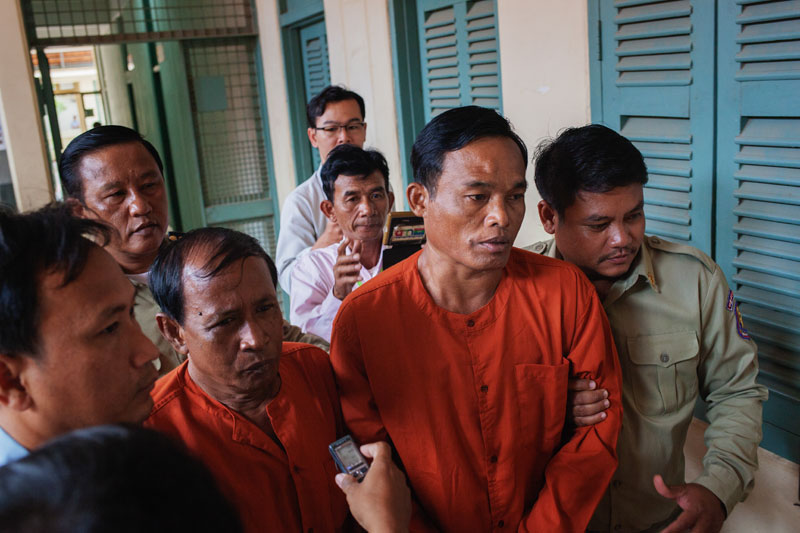 Prison guards escort Sieng Sarin, left, and Ka Sak from the Kandal Provincial Court on Thursday after they were handed seven-year sentences for their role in stealing relics of the Buddha from a pagoda in 2013. (Jens Welding Ollgaard/The Cambodia Daily)