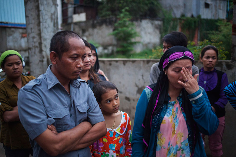 Chea Ty, left, the brother of Chea Sros, stands with fellow members of his community in Phnom Penh's Russei Keo district on Monday evening. (Jens Welding Ollgaard/The Cambodia Daily)