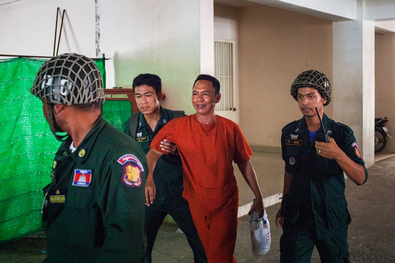 Brigadier General Pech Prum Mony is escorted from the Phnom Penh Municipal Court on Thursday. (Jens Welding Ollgaard/The Cambodia Daily)