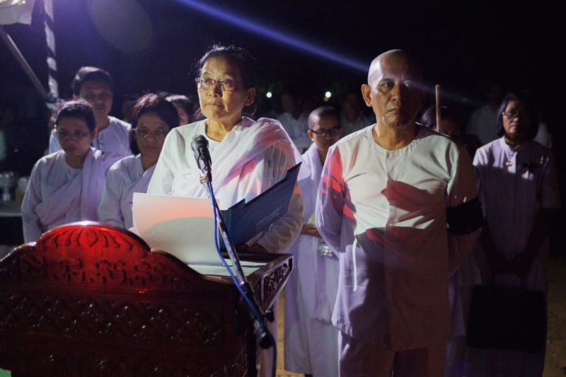 Ieng Thirith's daughter, Huon Vanny, reads the eulogy for her mother while standing next to her brother, Ieng Vuth, at their late parents' home in Pailin province on Monday night. (Jens Welding Ollgaard/The Cambodia Daily)