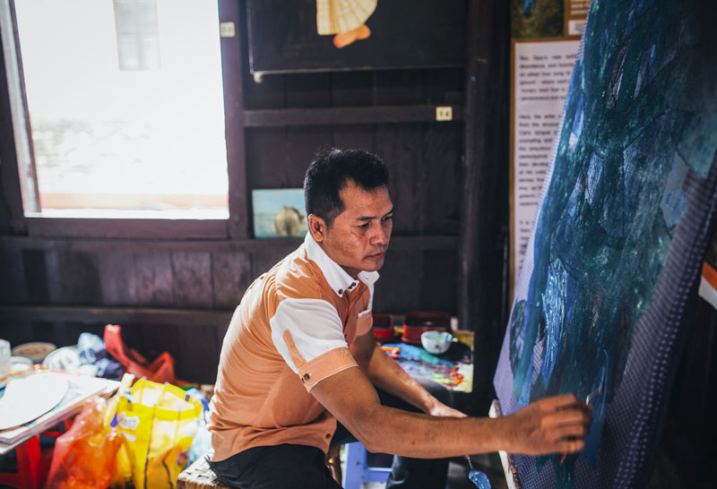 Nou Sary paints earlier this month at his studio in Siem Reap City. (Nataly Lee)
