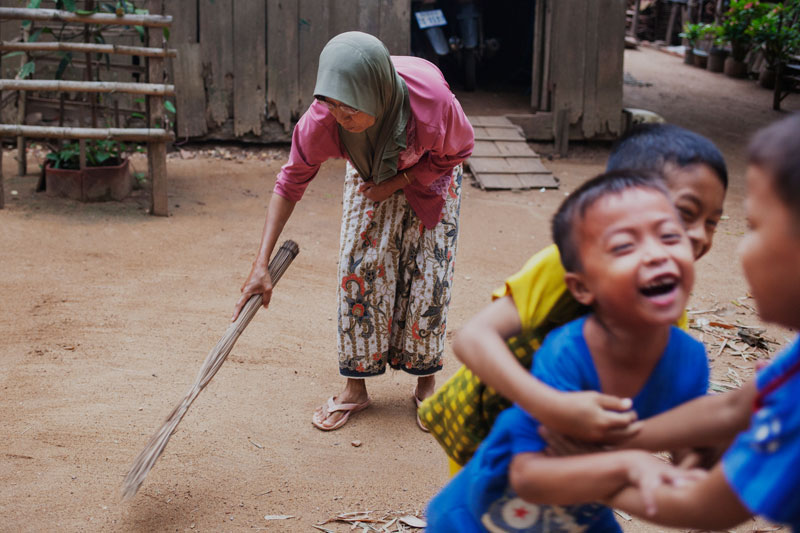 A Cham woman sweeps outside her house. (Jens Welding Ollgaard/The Cambodia Daily)