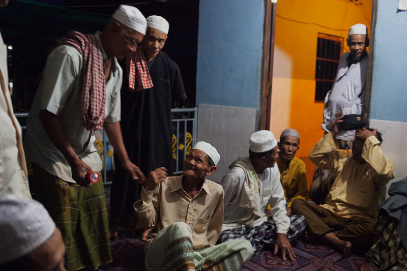 Locals talk outside the mosque in Tbong Khmum province’s Svay Khleang village after evening prayers on Monday. (Jens Welding Ollgaard/The Cambodia Daily)