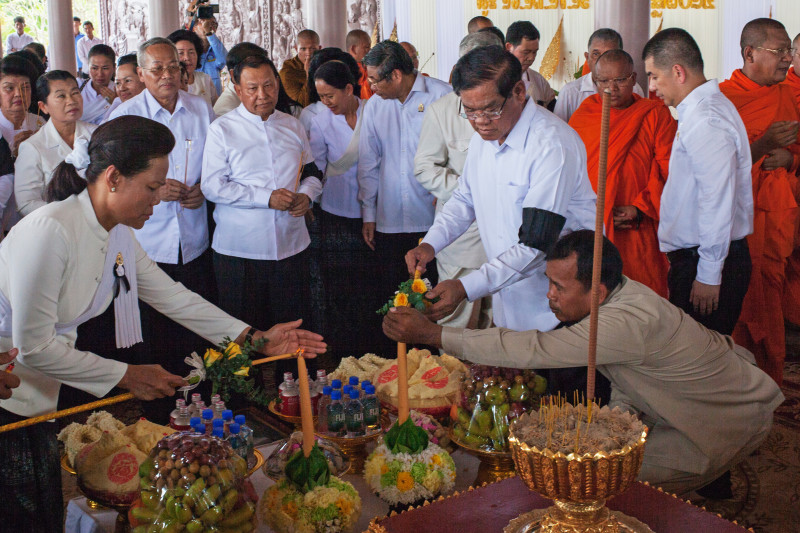 Interior Minister Sar Kheng, right, lights incense at a ceremony on Friday to deliver Chea Sim's ashes to a stupa on his family's estate. (Jens Welding Ollgaard/The Cambodia Daily)