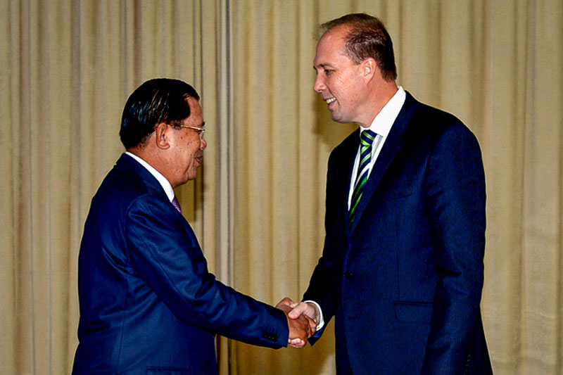 Prime Minister Hun Sen, left, shakes hands with Australian Immigration Minister Peter Dutton at Mr Hun Sen's office building in Phnom Penh on Wednesday. (Khem Sovannara)