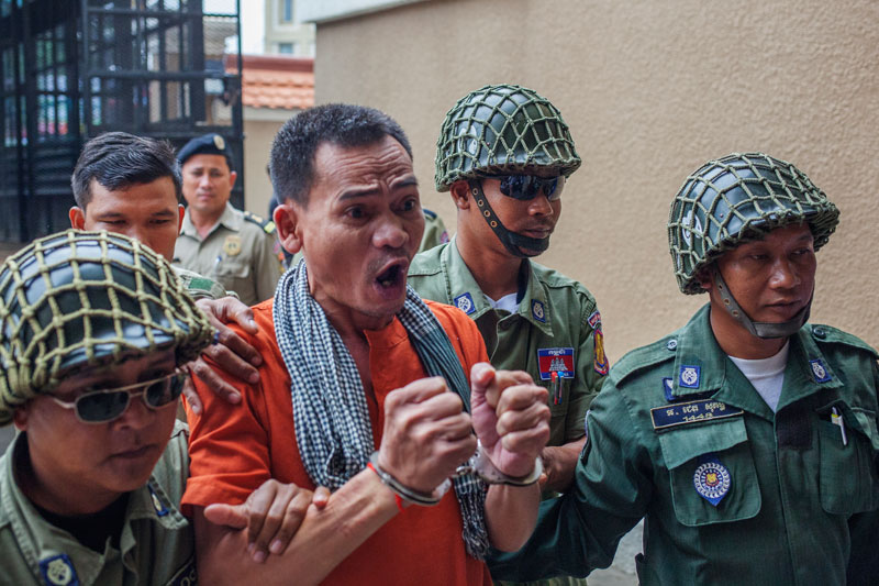 Imprisoned activist Ouk Pich Samnang is escorted by police Thursday morning into the Phnom Penh Municipal Court, where he was given a further two years in jail. (Jens Welding Ollgaard /The Cambodia Daily)